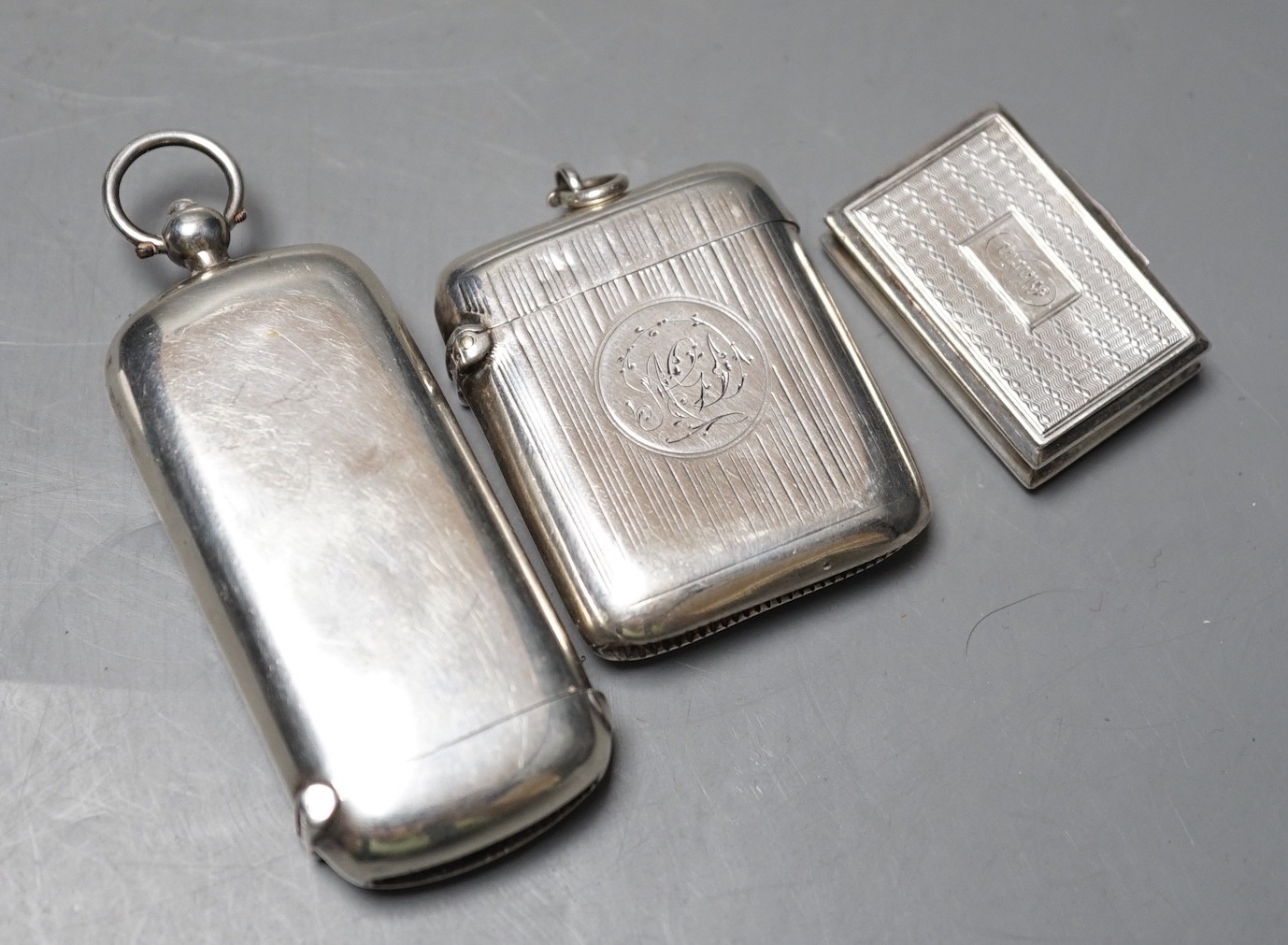 An Edwardian silver combination vesta/sovereign case, Chester, 1903, 73mm, together with a Victorian silver vinaigrette and a silver vesta case.